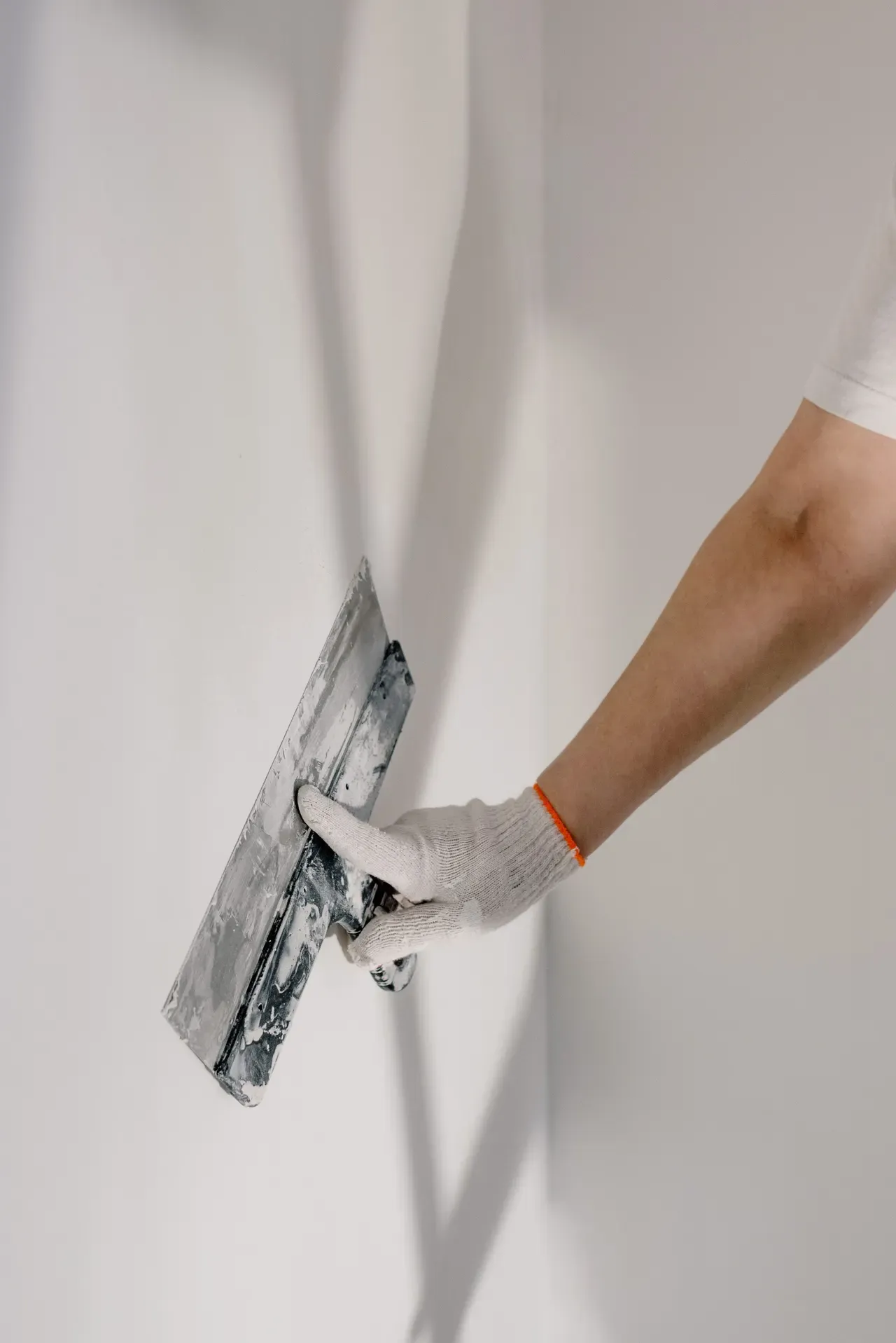 Application d'un enduit de finition à la spatule sur un mur